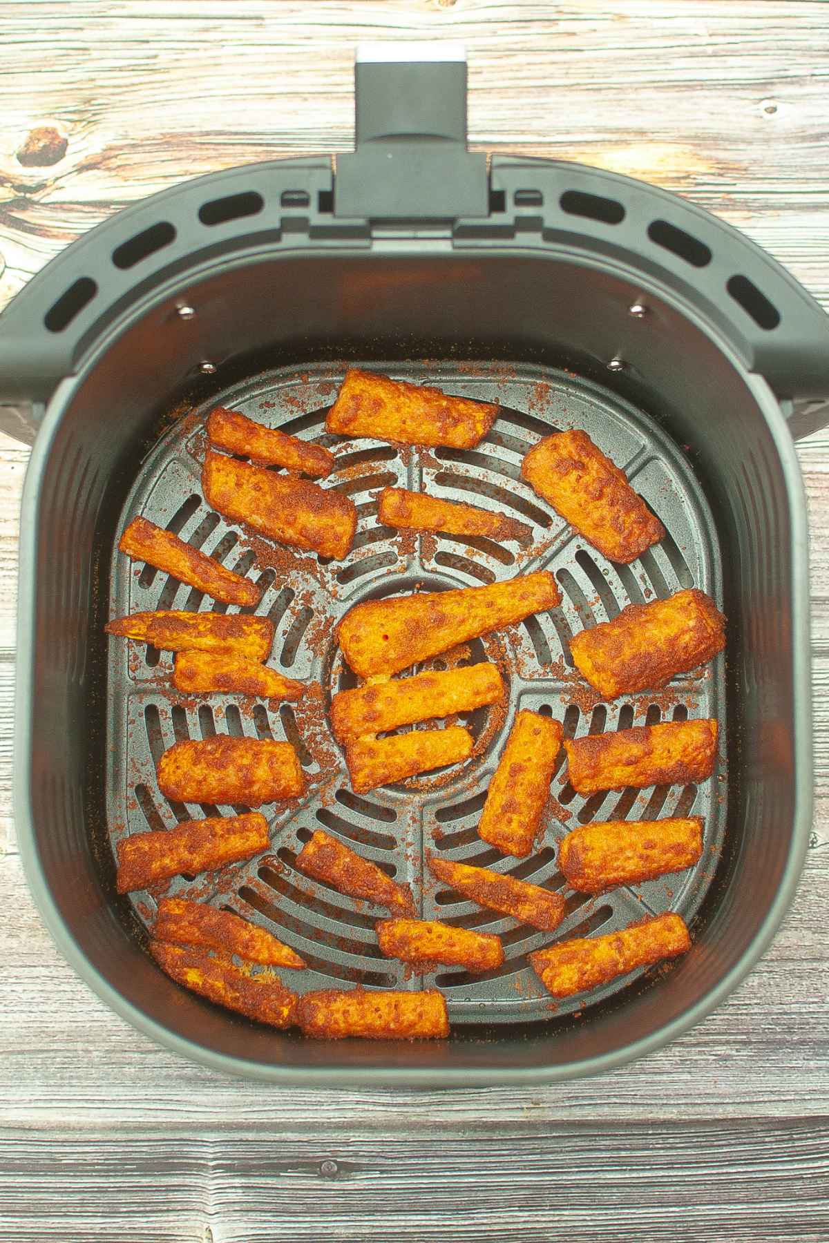 Crispy carrot fries in the air fryer basket.