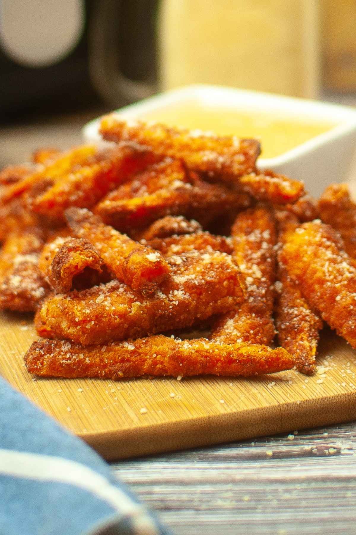 Hero image for Air Fryer Carrot Fries, on a cutting board sprinkled with parmesan.