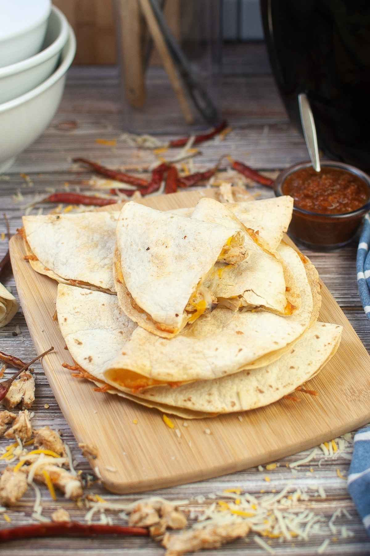 A stack of air fryer chicken quesadilla on a wooden board.