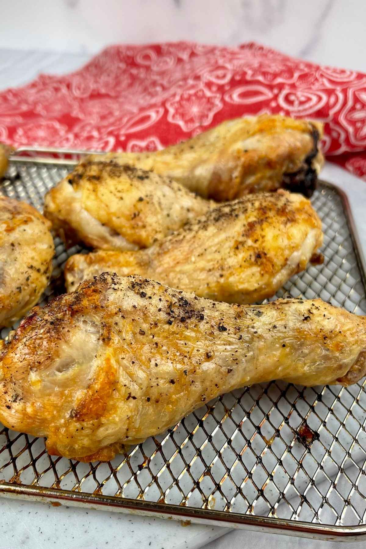 Air fried chicken drumsticks on a tray.