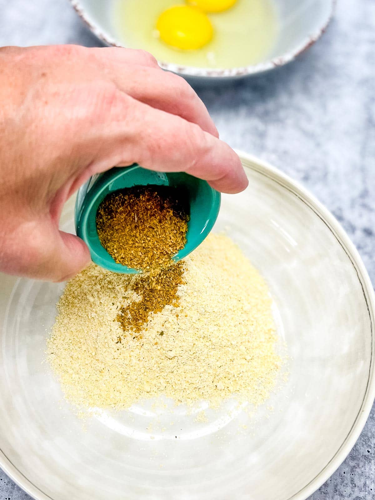 Pouring the seasoning into the corn meal.