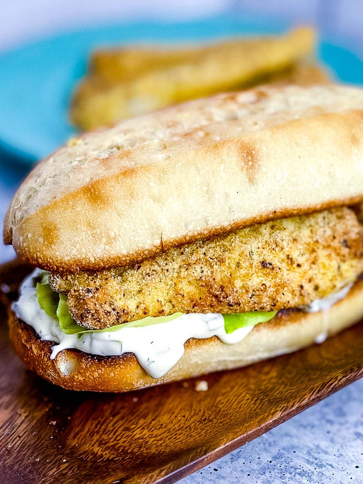 A fish sandwich made with air fryer fish sticks on a brown tray.