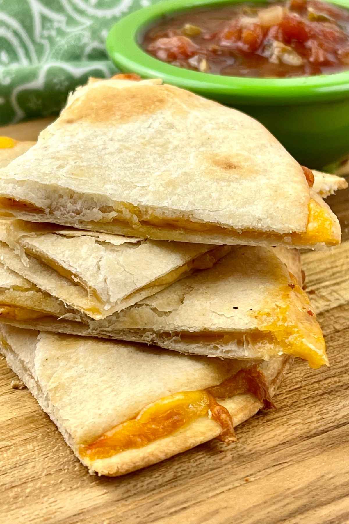 A stack of air fryer quesadillas with salsa in the background.