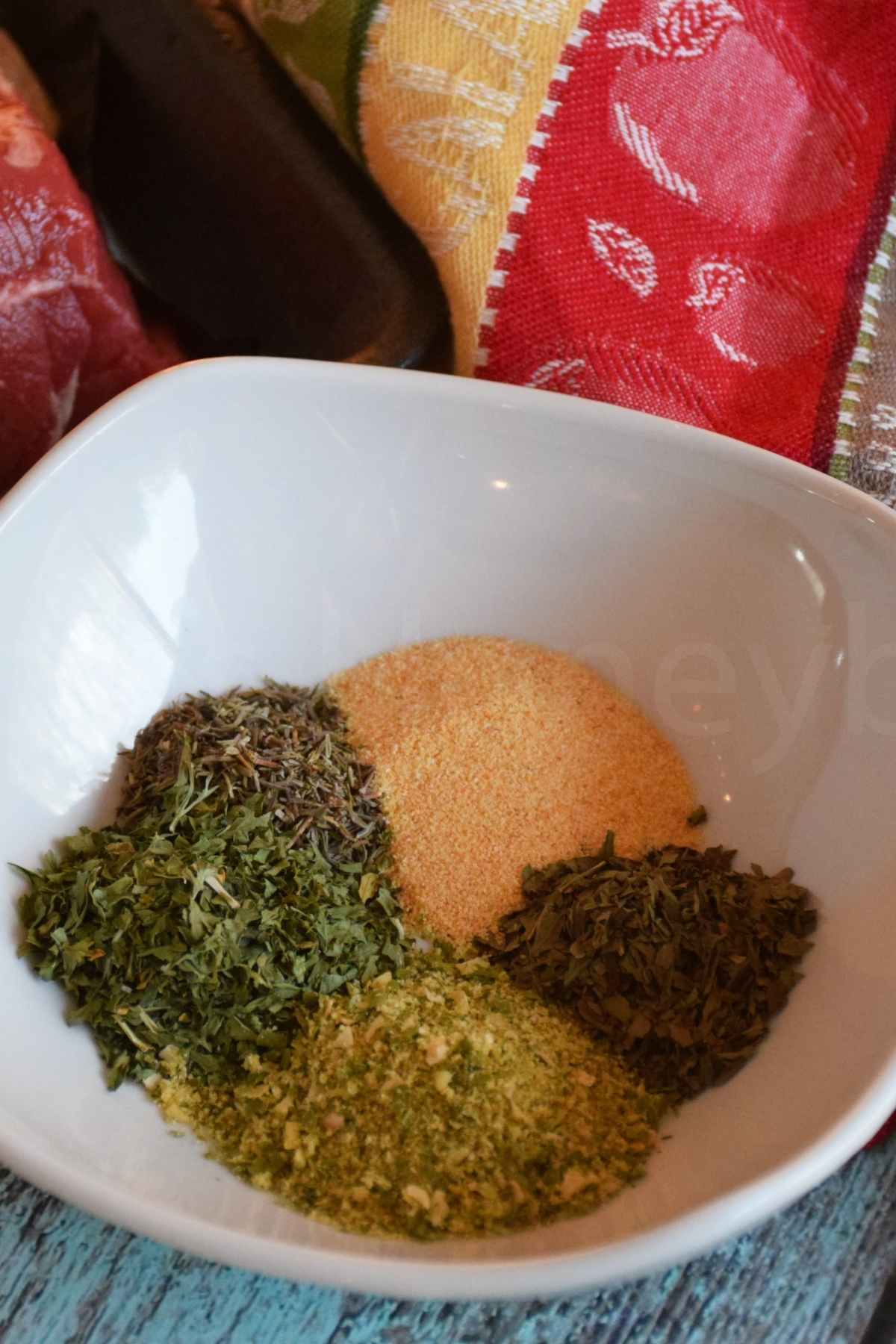 A white bowl with herbs for the herb crust.