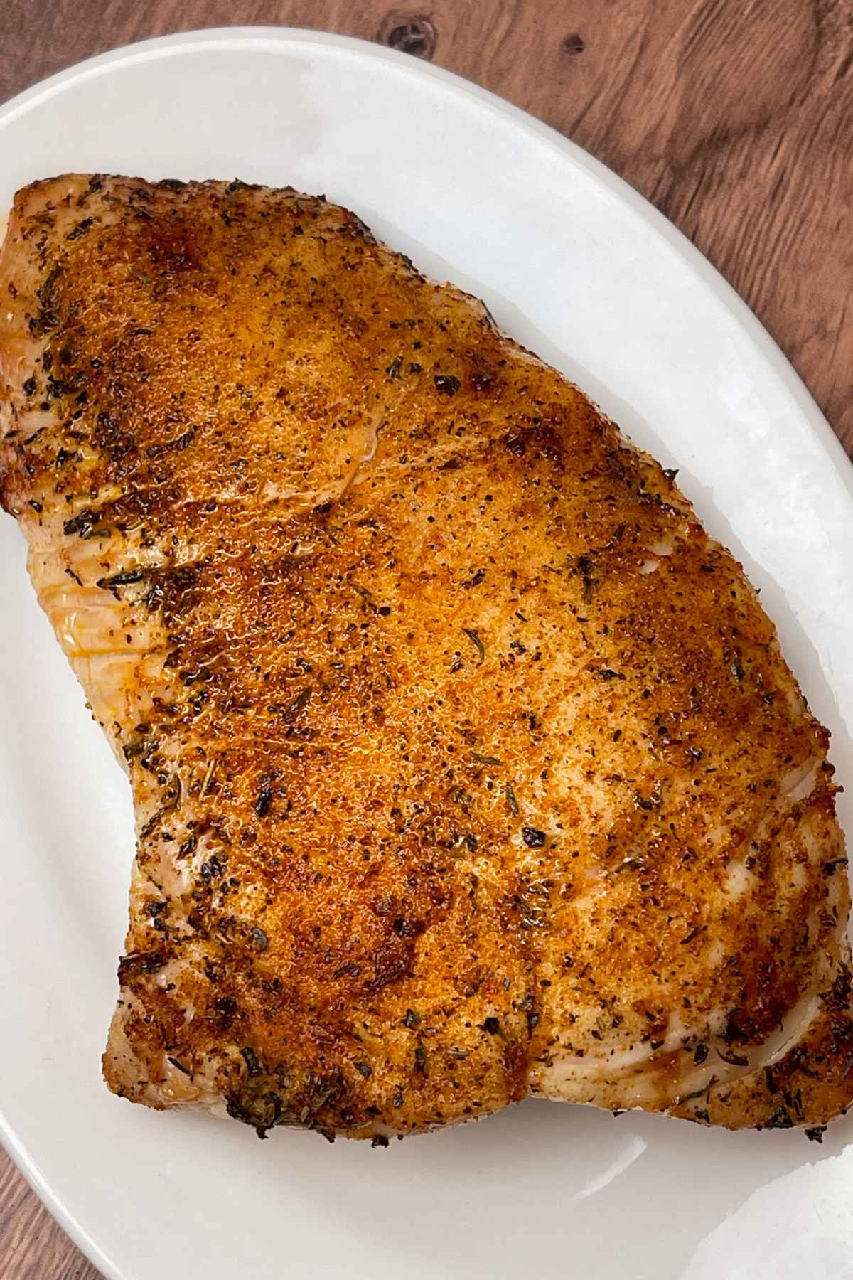 Golden brown roasted turkey tenderloin on a white tray.