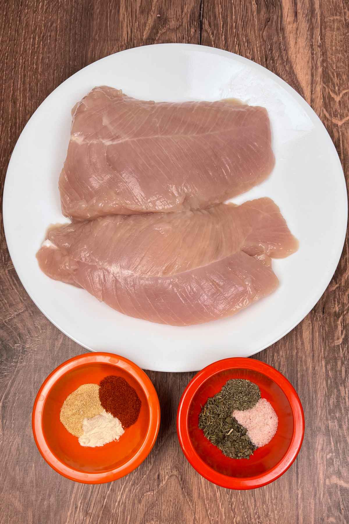 Tenderloins with seasonings portioned out into bowls.