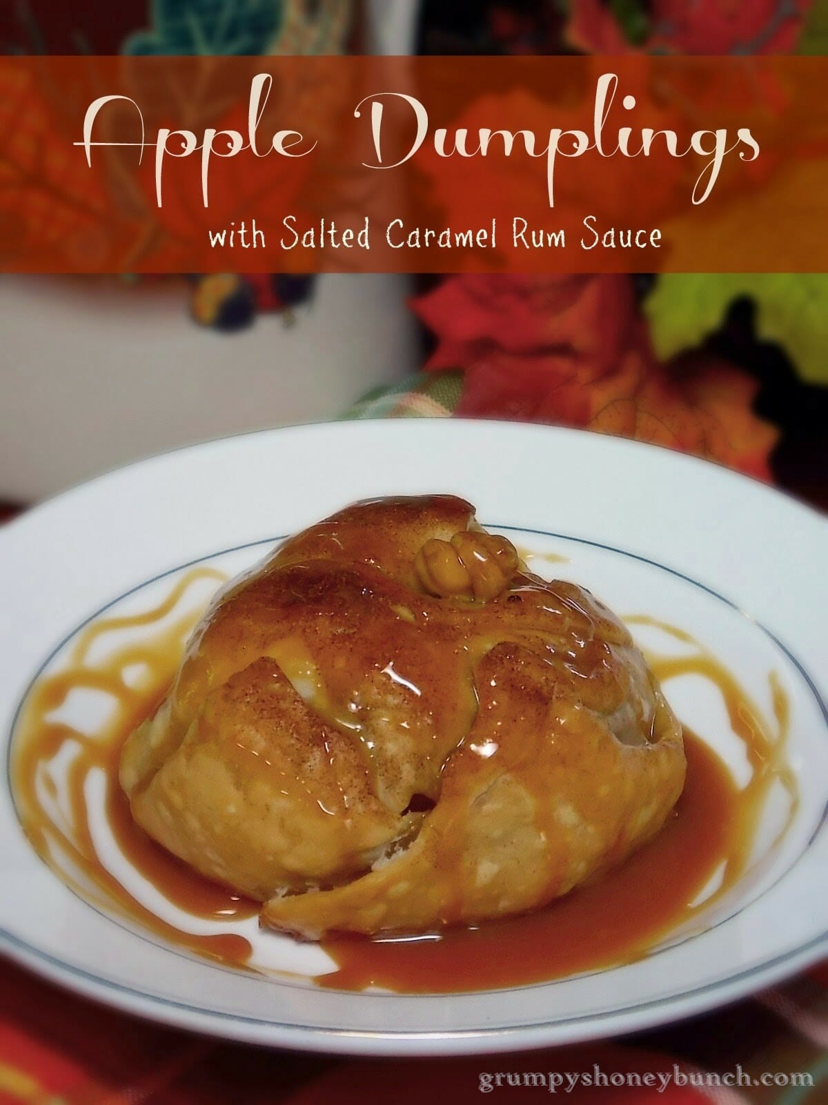 One apple dumpling on a plate with salted caramel sauce drizzled over top.