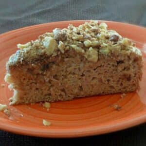 Apple Walnut Coffee Cake slice on an orange plate.