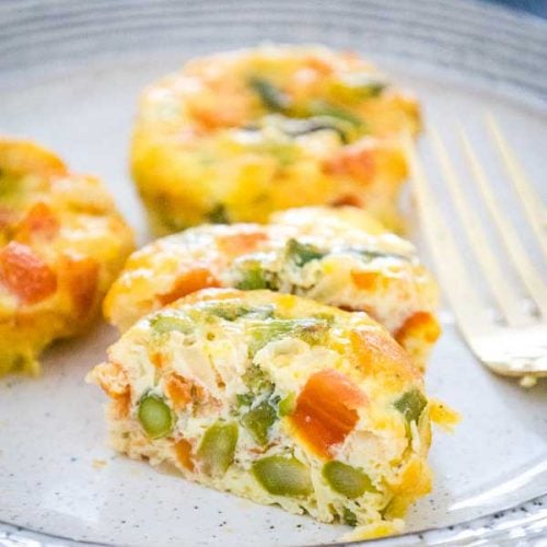 Three Egg Muffin Cups on a plate with one cut in half