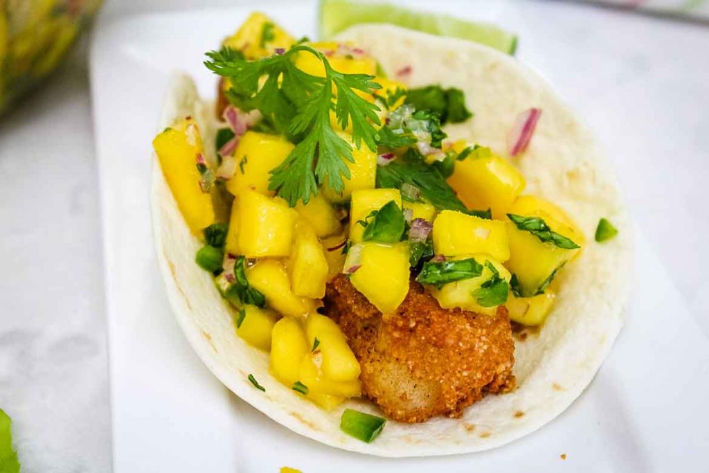 Flour Tortilla filled with fried cod strips and mango salsa