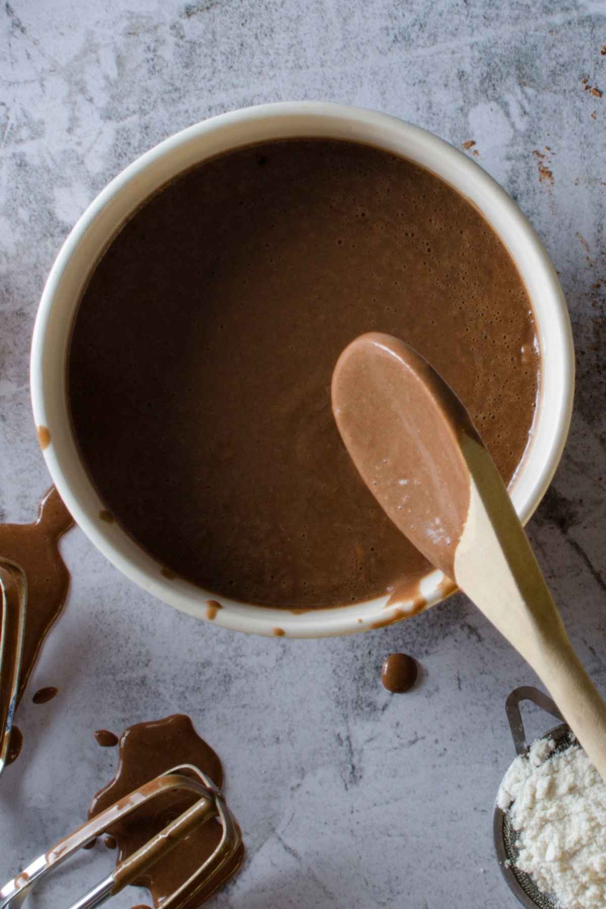 Chocolate Batter in mixing bowl with wooden spoon.
