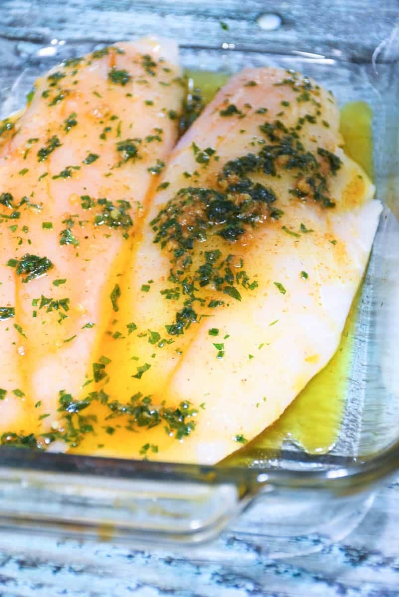 Filets in baking dish with butter and herbs.
