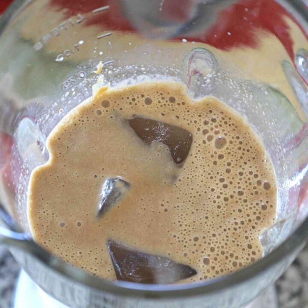 Smoothie ingredients in the blender with ice before blending.