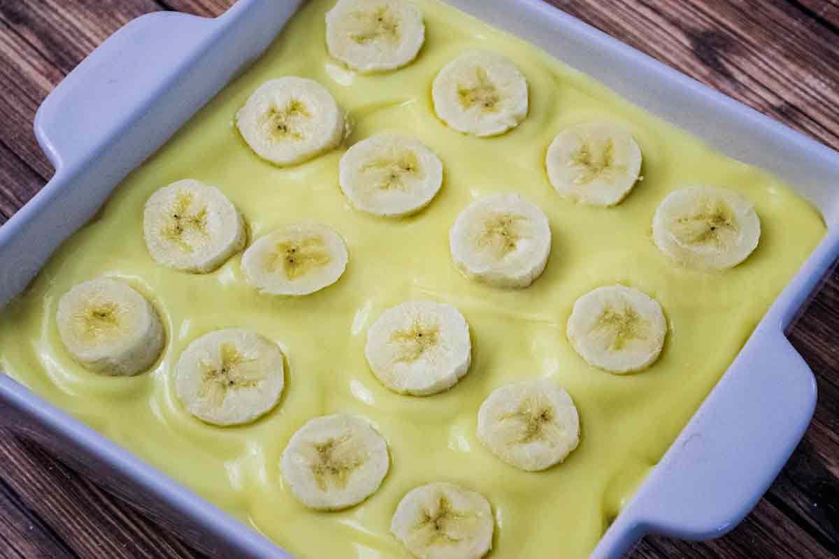 Banana topped pudding in a square dish.