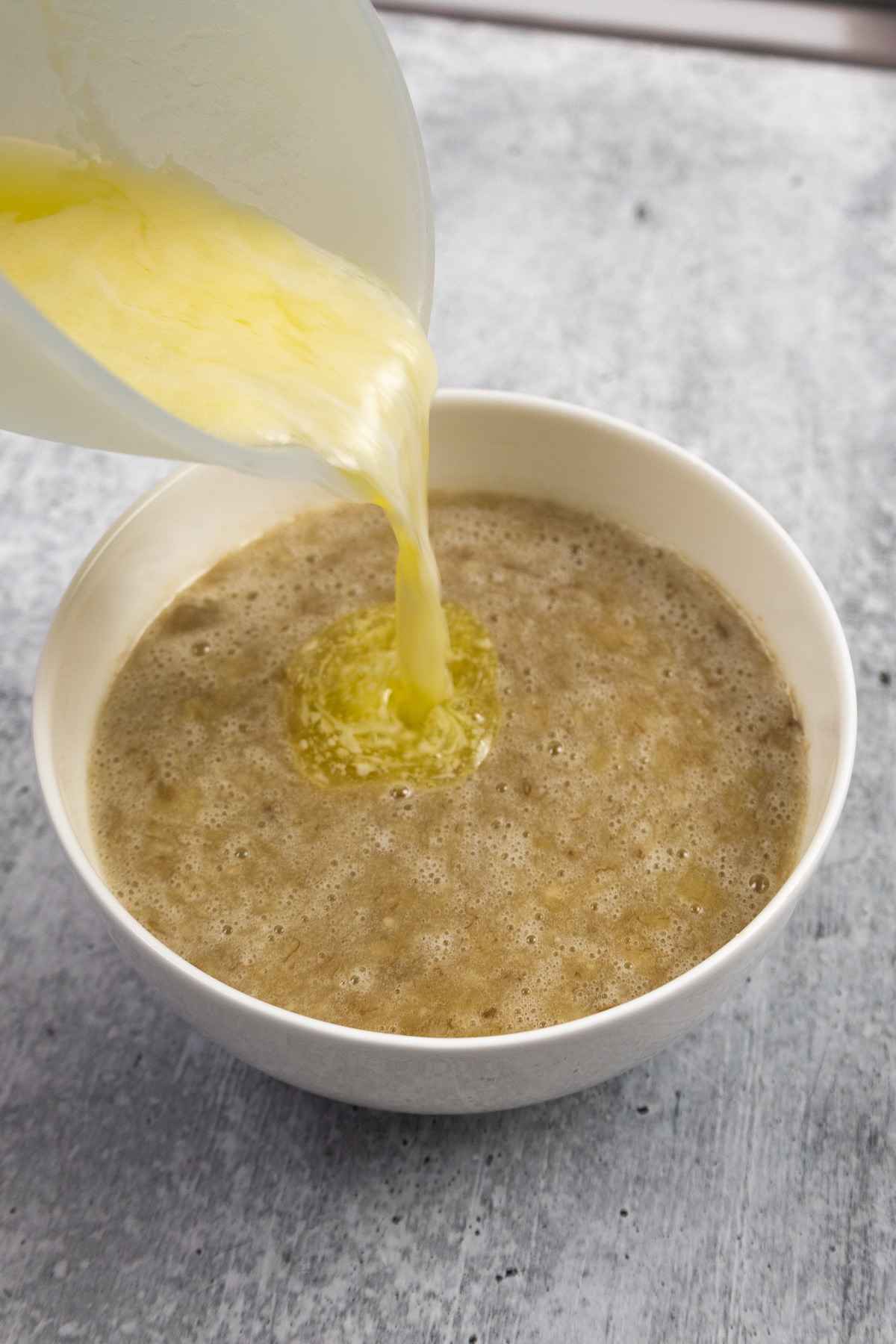 Pouring melted butter into mashed banana mixture