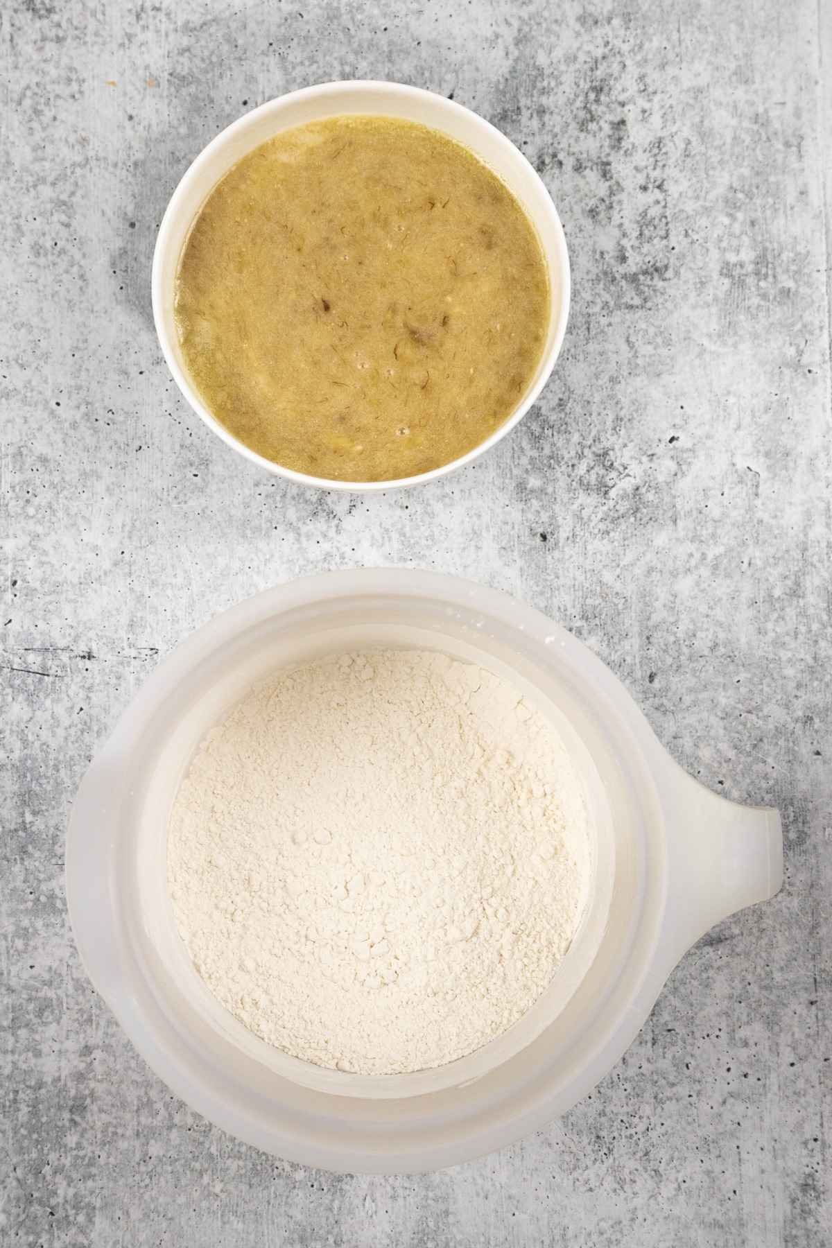 Banana mixture and flour mixture in separate bowls.