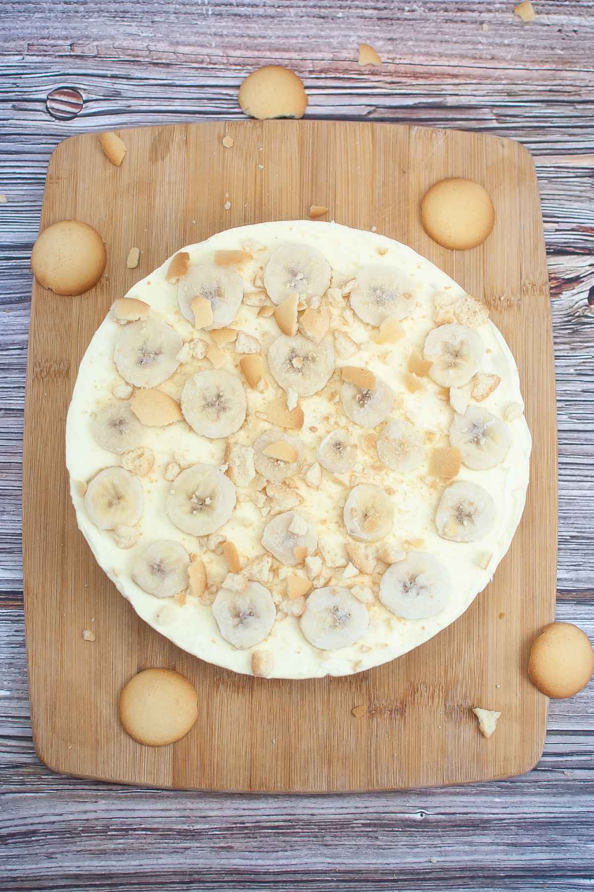 Overhead image of banana pudding cheesecake garnished with crushed vanilla cookies.