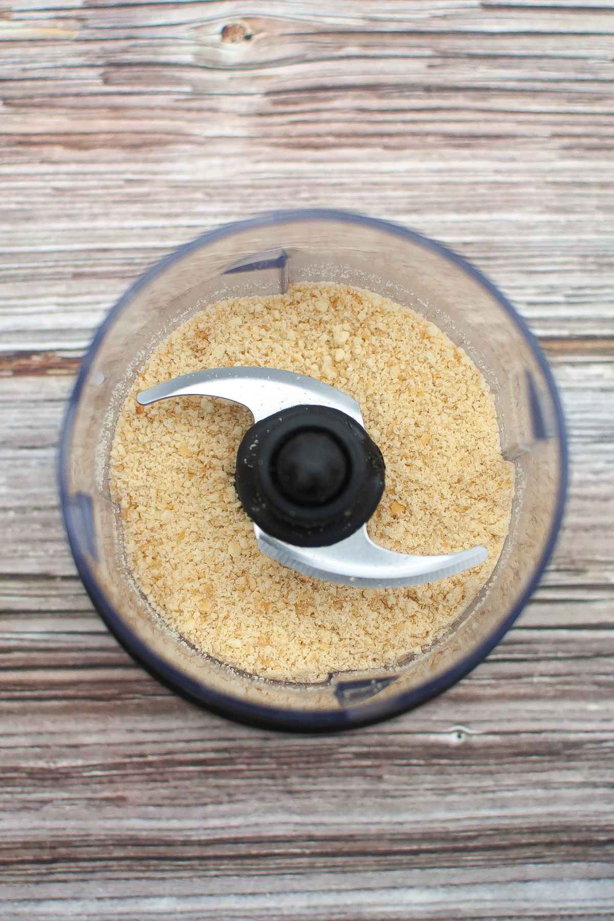 Food processor filled with crust mixture.