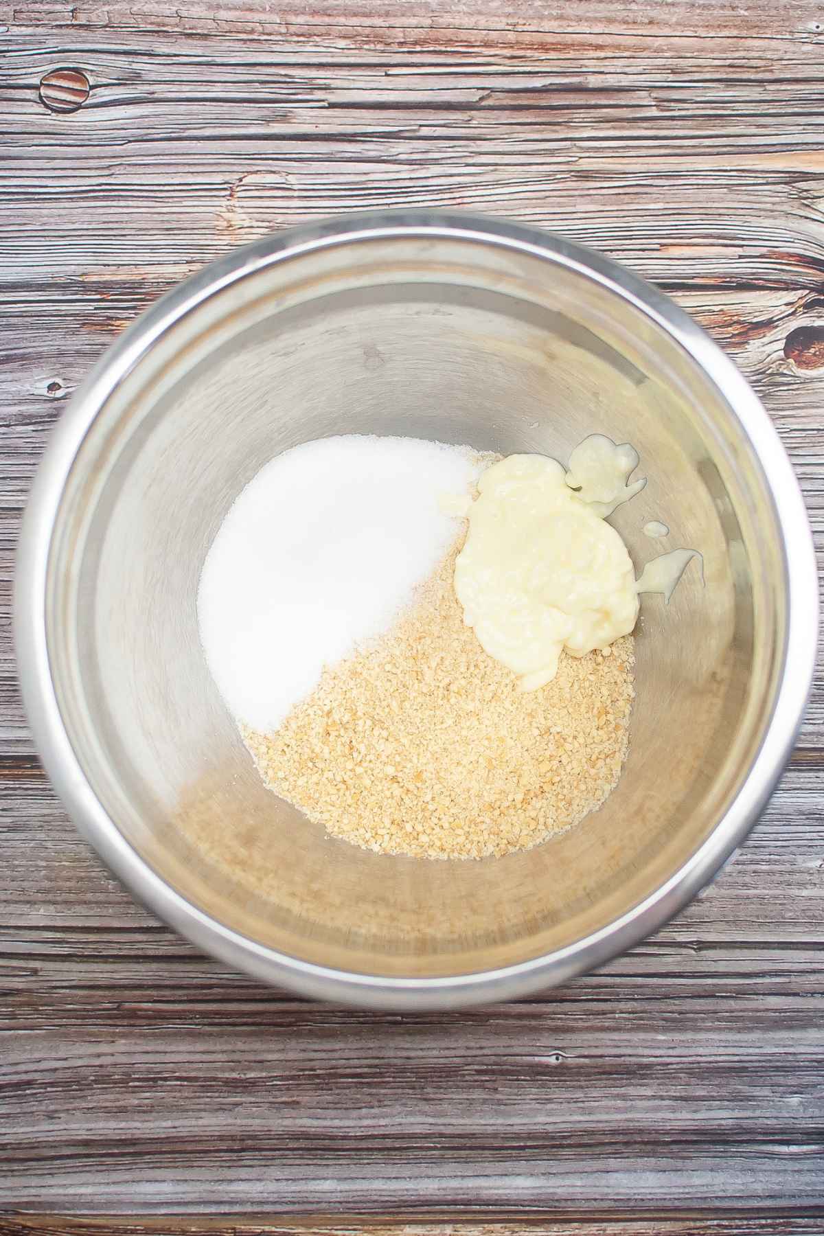 Crust mixture in a stainless steel bowl.