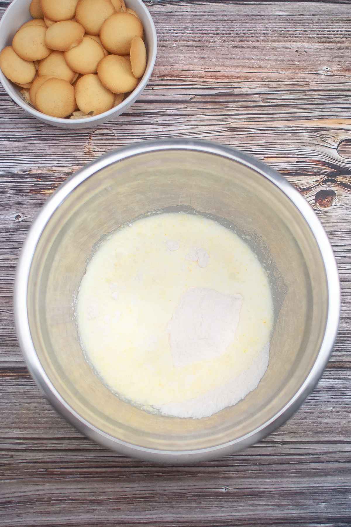 Milk and instant pudding mix in a stainless steel bowl.