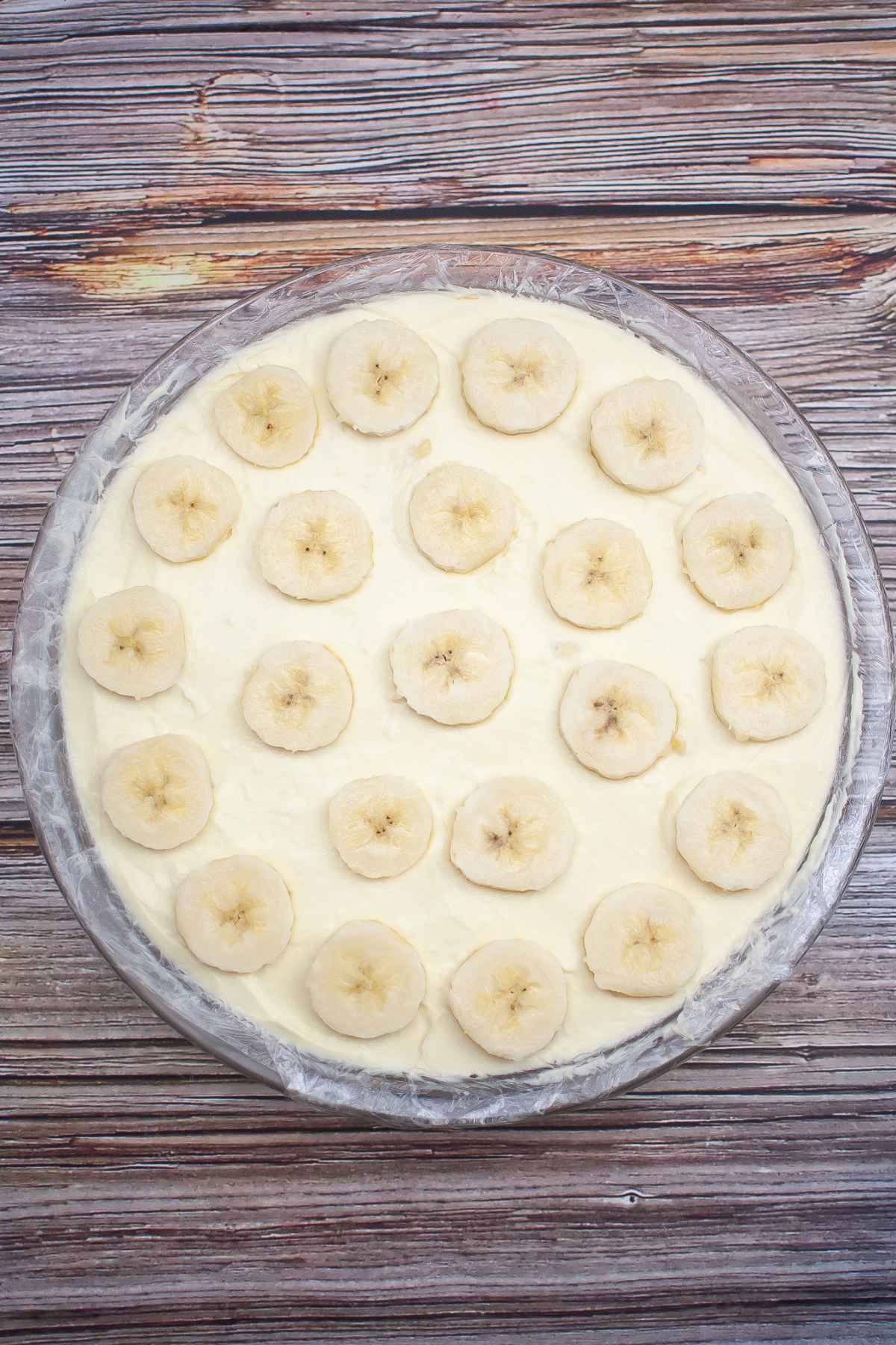 Overhead image of banana pudding cheesecake topped with banana slices.