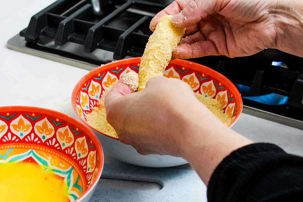 Battering cod fish sticks with flour free coating for frying