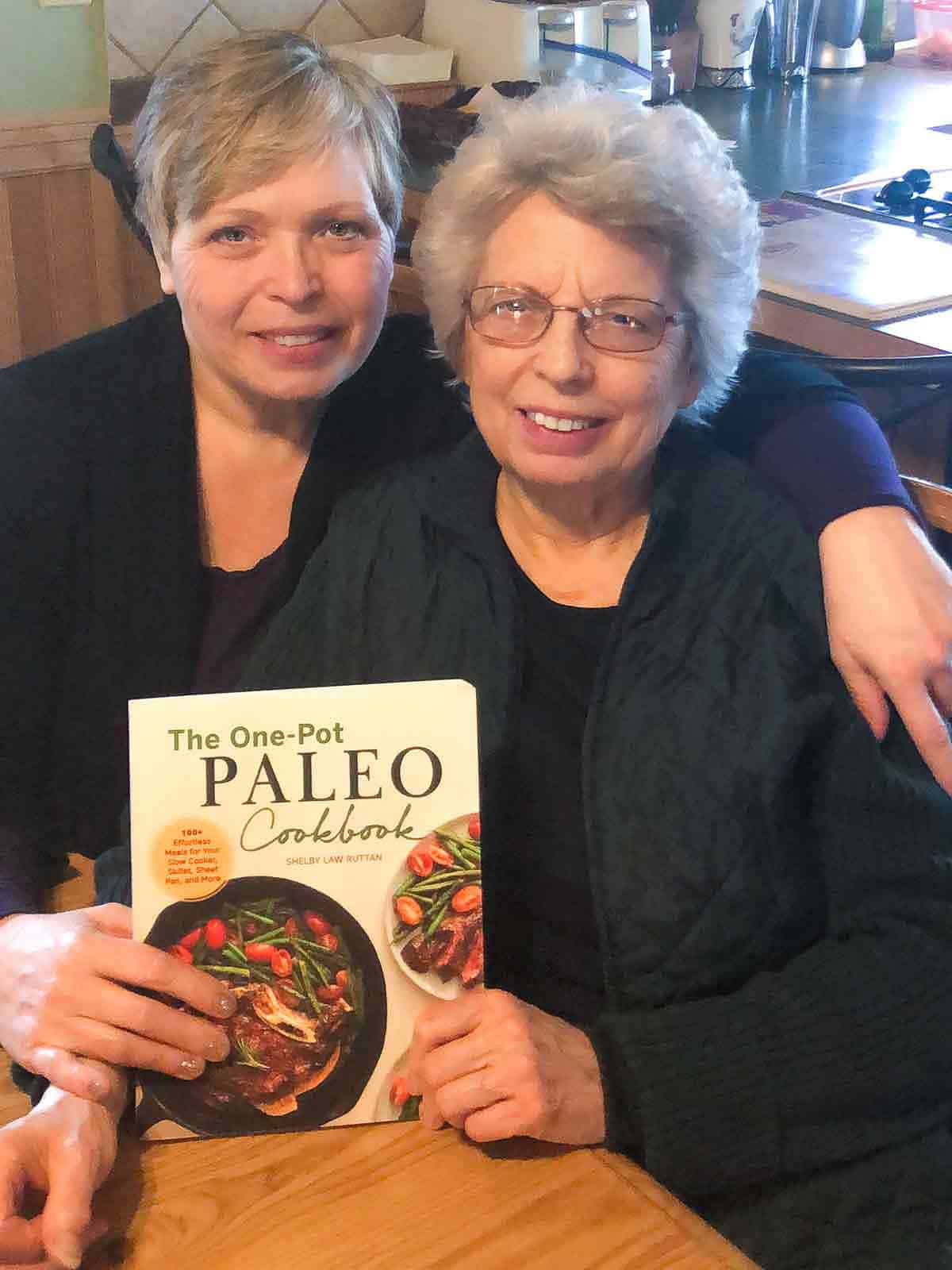 Shelby Law Ruttan and her mother, Gwen Law, holding the One Pot Paleo Cookbook.