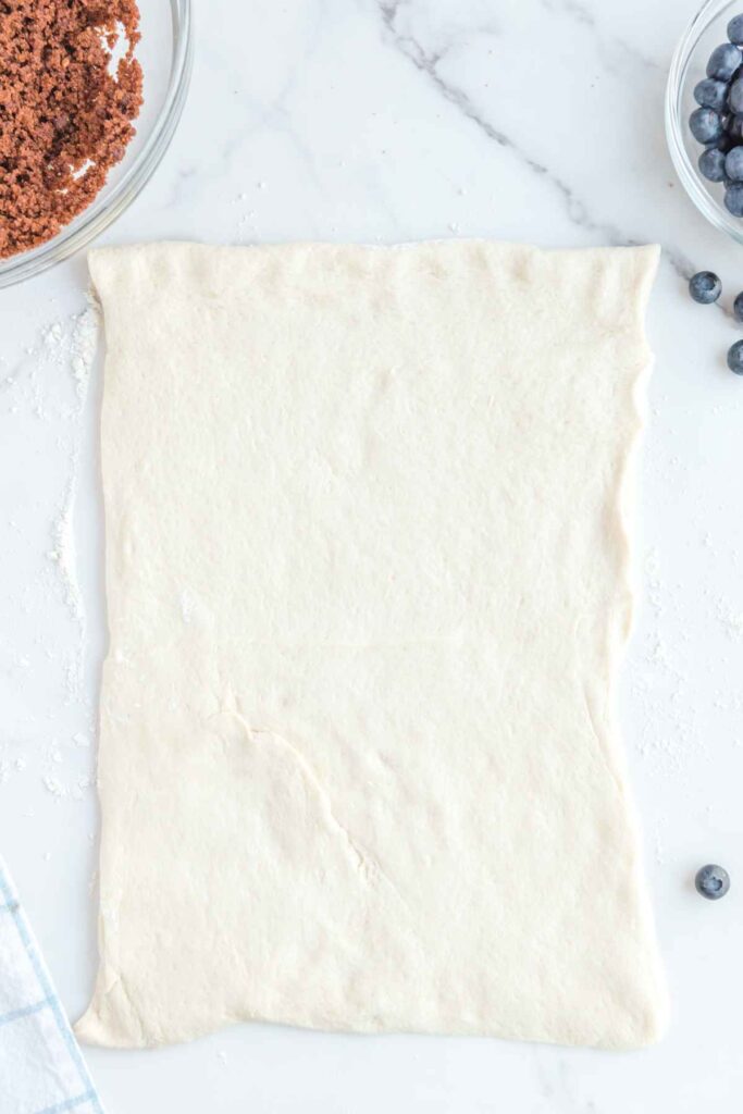 Dough that has been rolled out on a marble board.