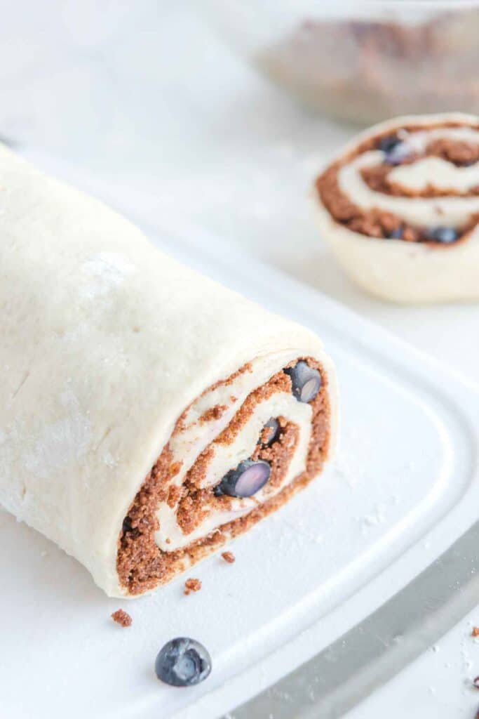 A rolled and sliced cinnamon roll dough.