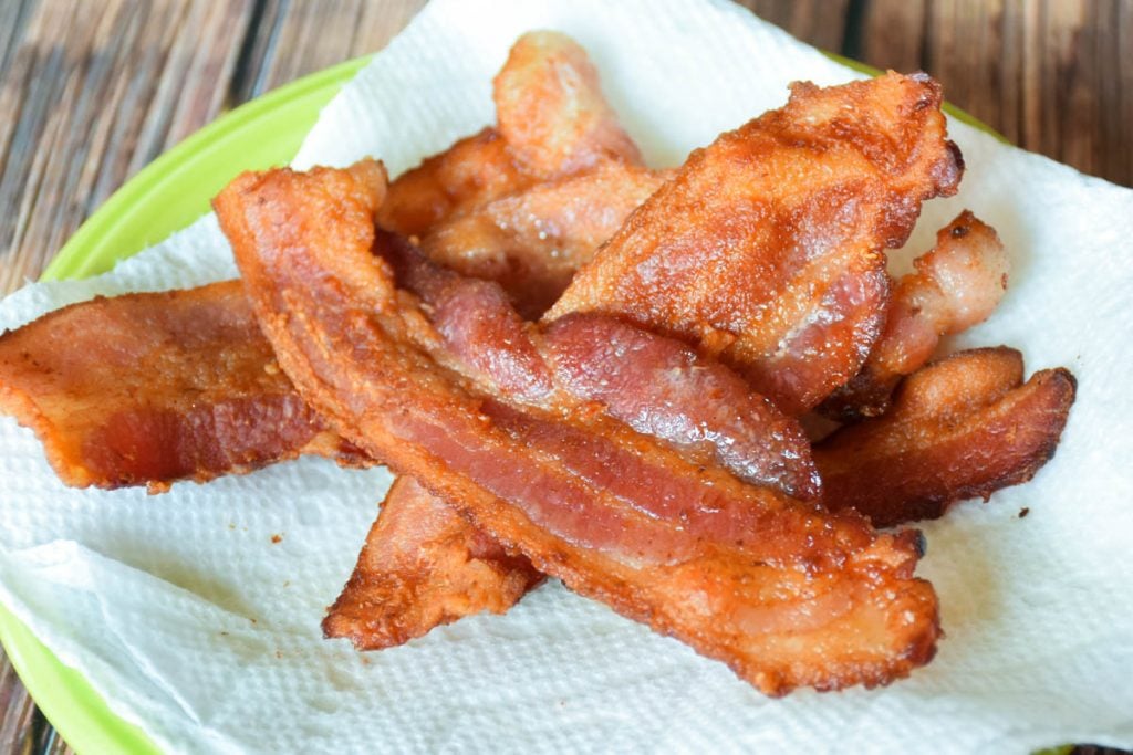 Crispy fried bacon on a paper towel lined plate