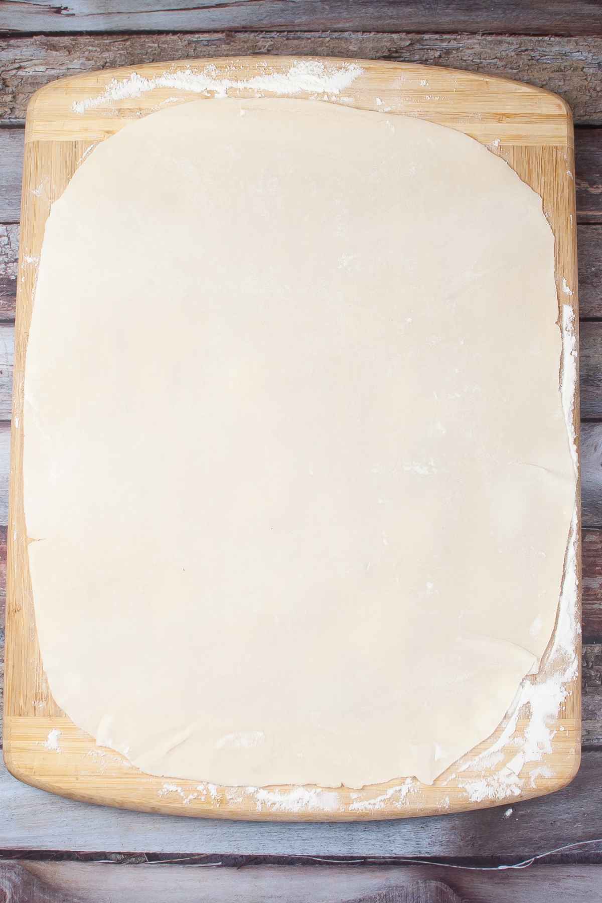 Pie crust on a floured board rolled out thin.