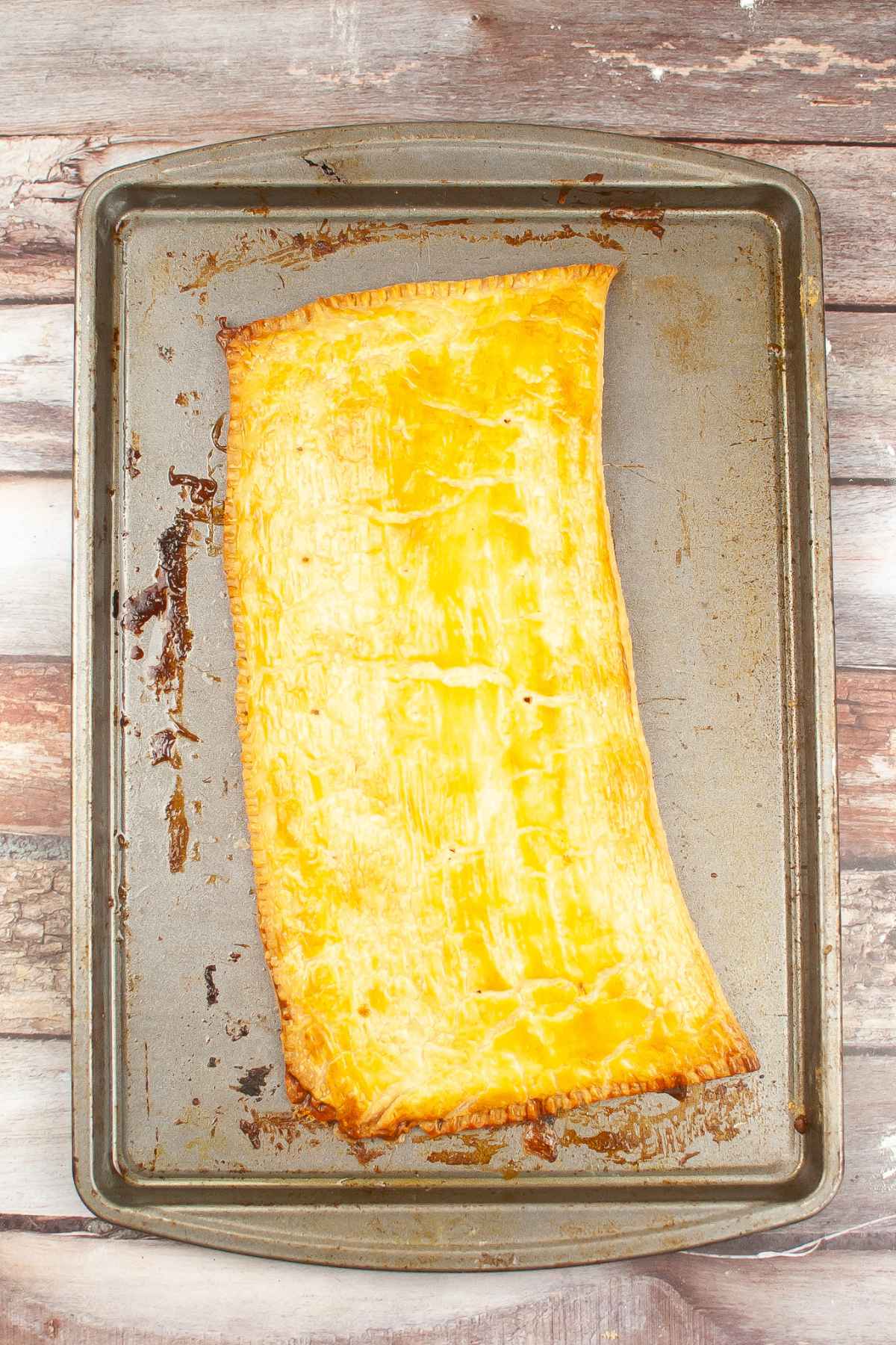 Golden brown baked homemade brown sugar cinnamon pop tart on baking sheet without icing.