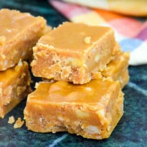 Featured image of Nanny's Brown Sugar Fudge cut in squares and stacked on a marble board.