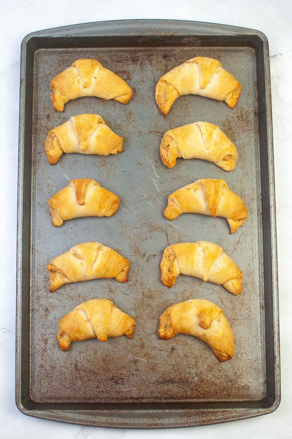 Golden brown crescent rolls on baking sheet