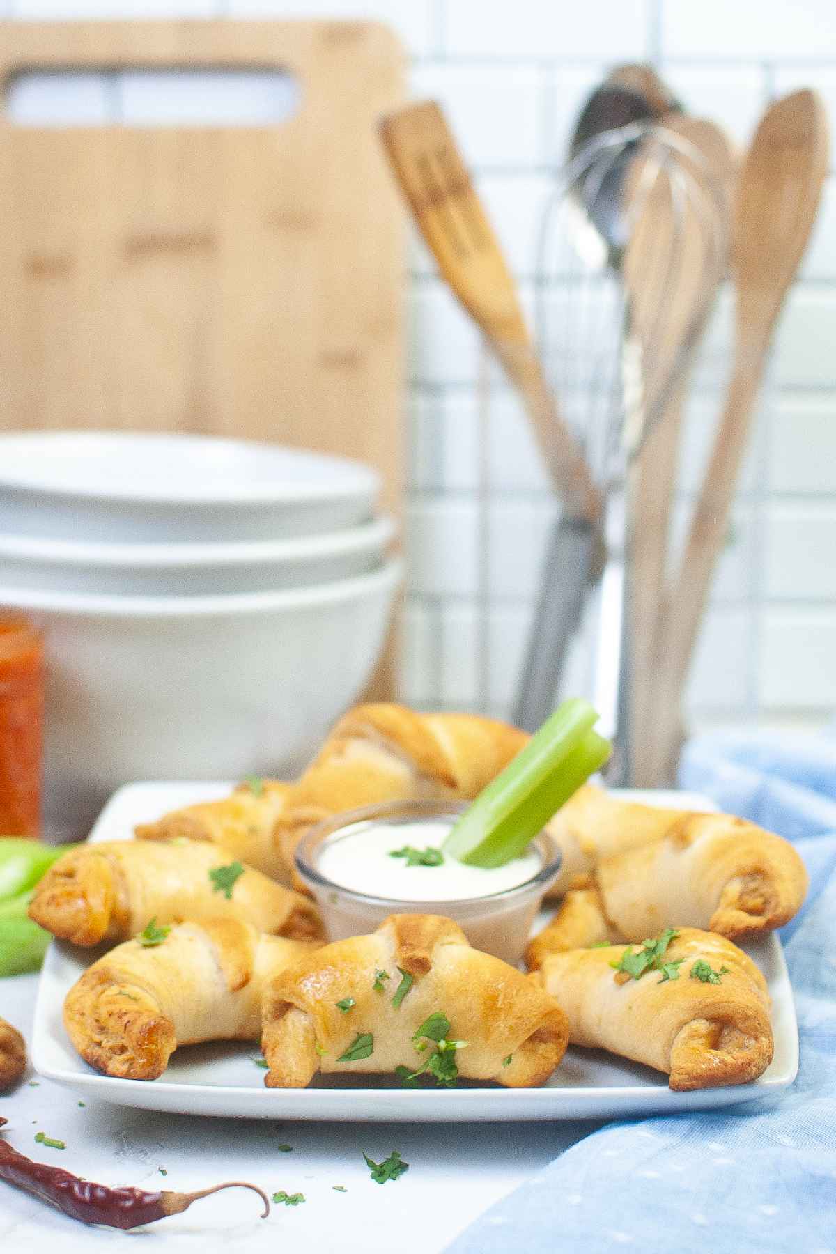 Side view of chicken wrapped pastry on a white plate.