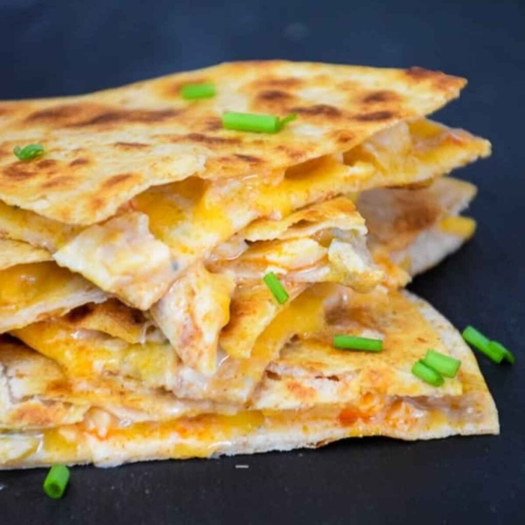 Stacked triangles of a buffalo chicken quesadilla.