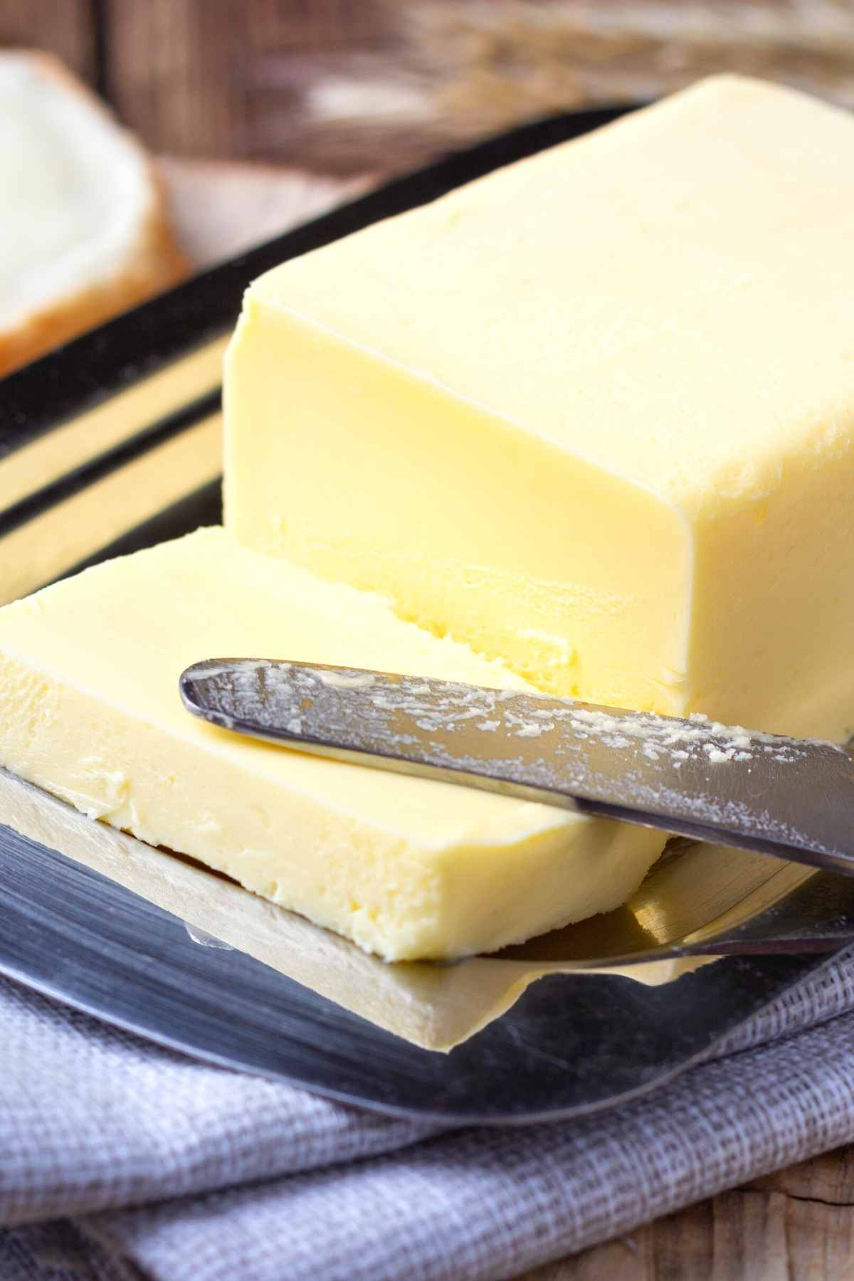 Butter on a plate with a knife and cut slice.