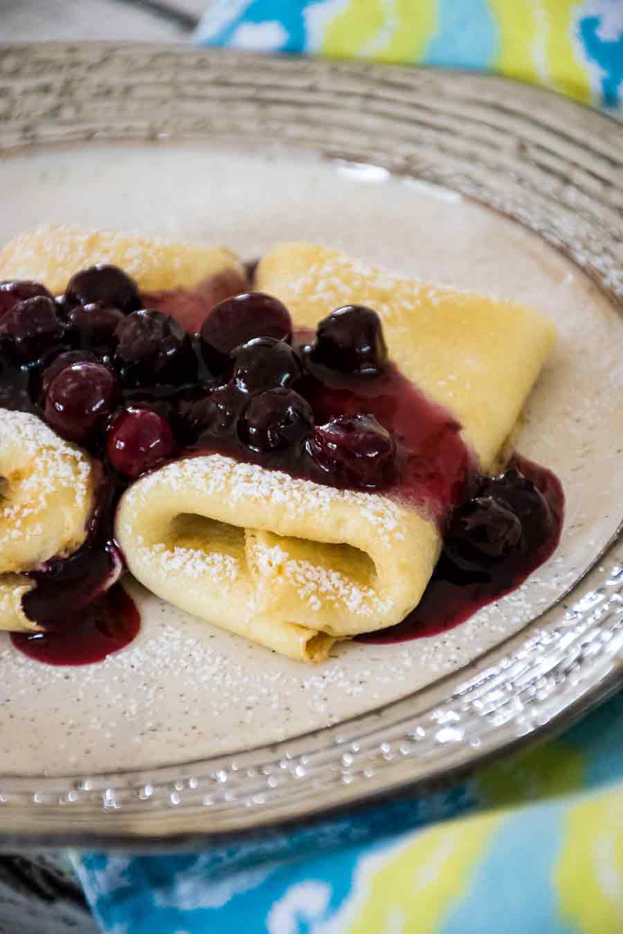 Cheese Blintzes with blueberry topping dusted with powdered sugar.