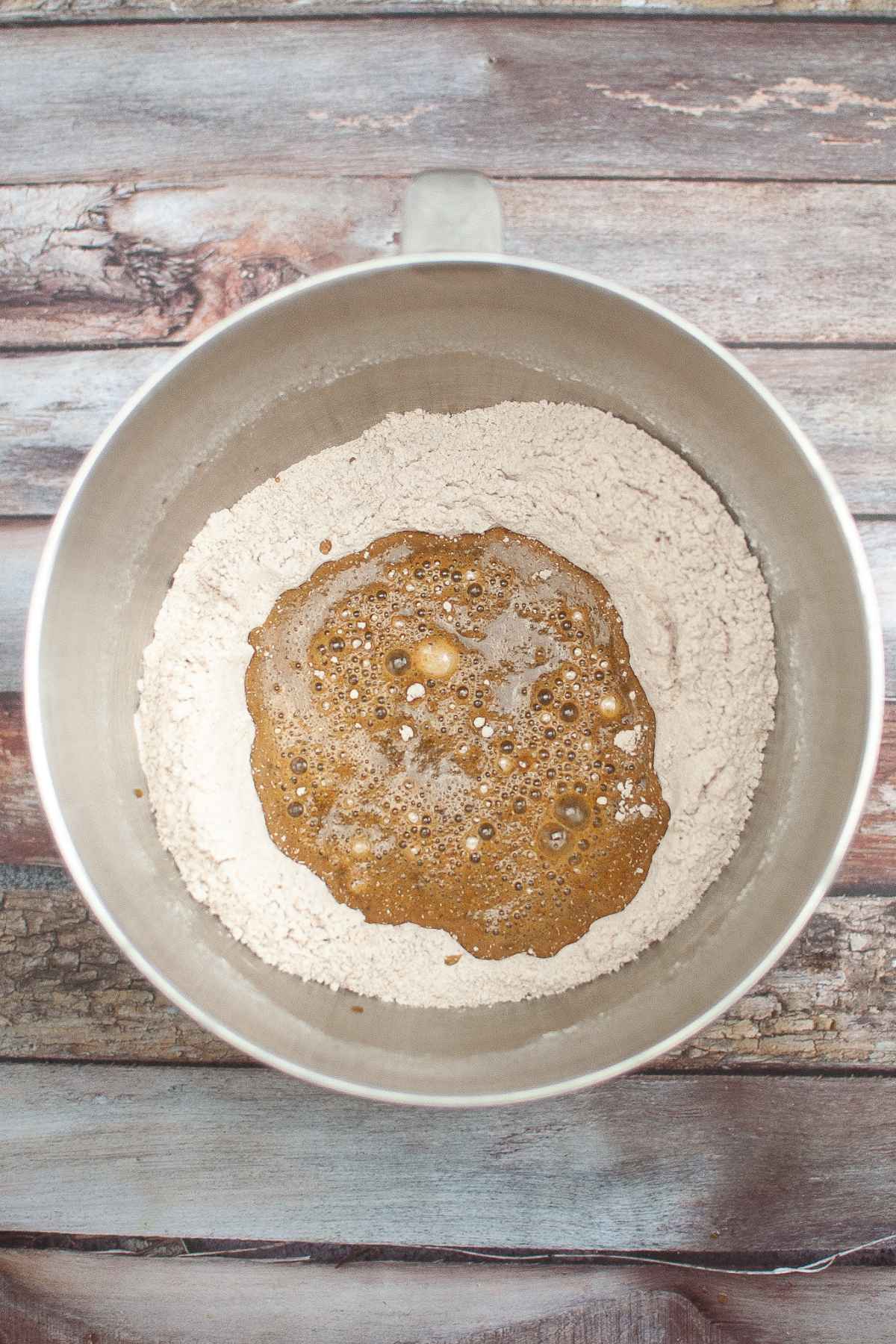 Wet and dry ingredients in bowl of a stand mixer.