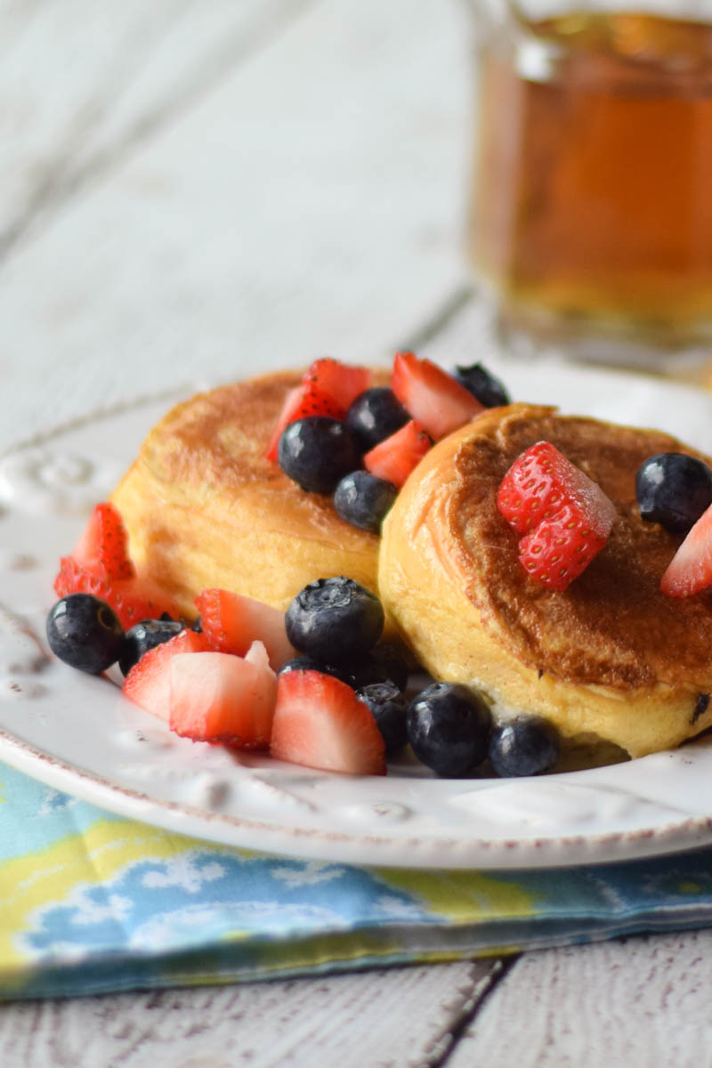 Upclose image of Cheesecake Stuffed French Toast Sliders topped with fruit.