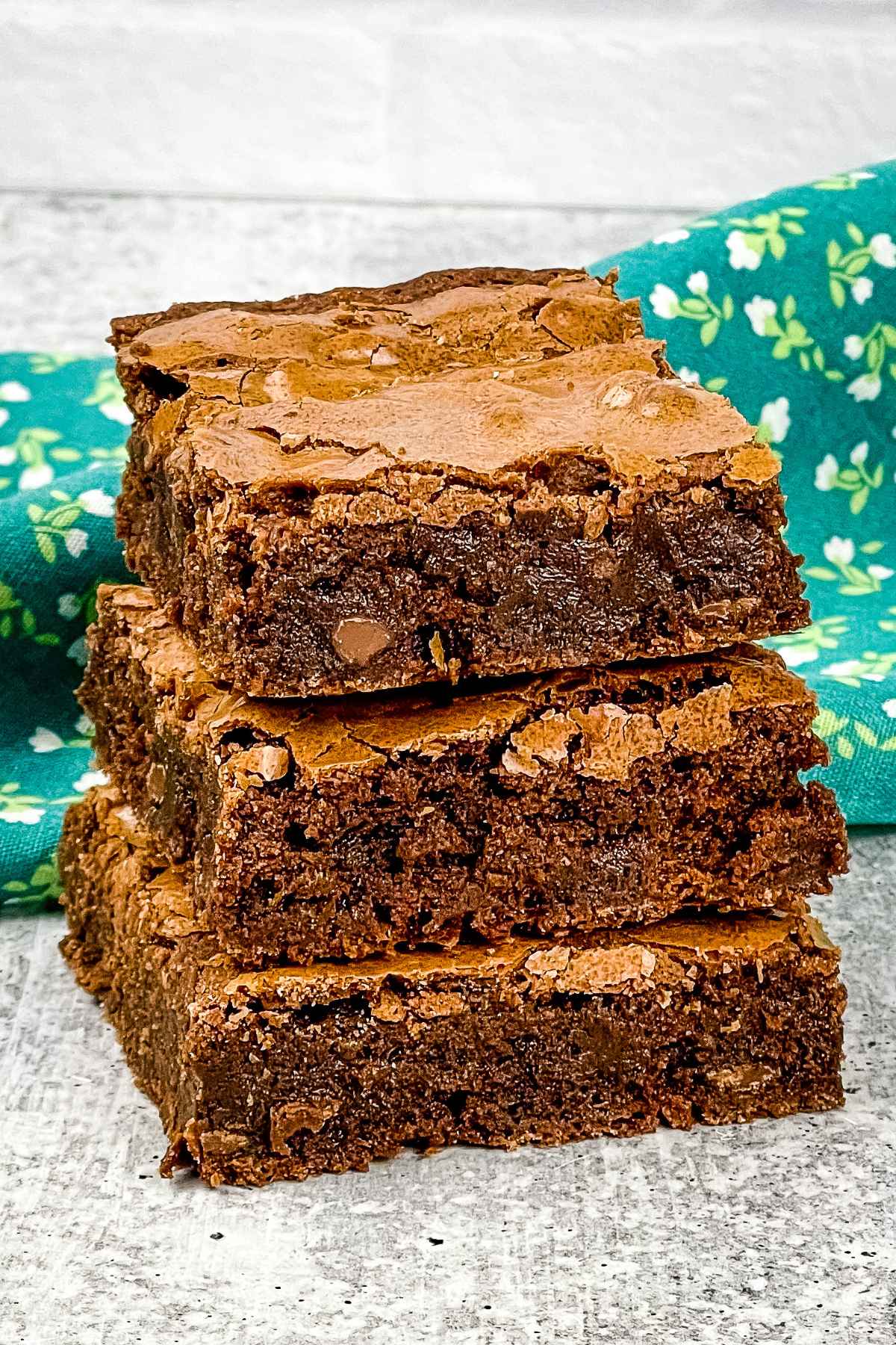 A stack of three chocolate fudge brownies.