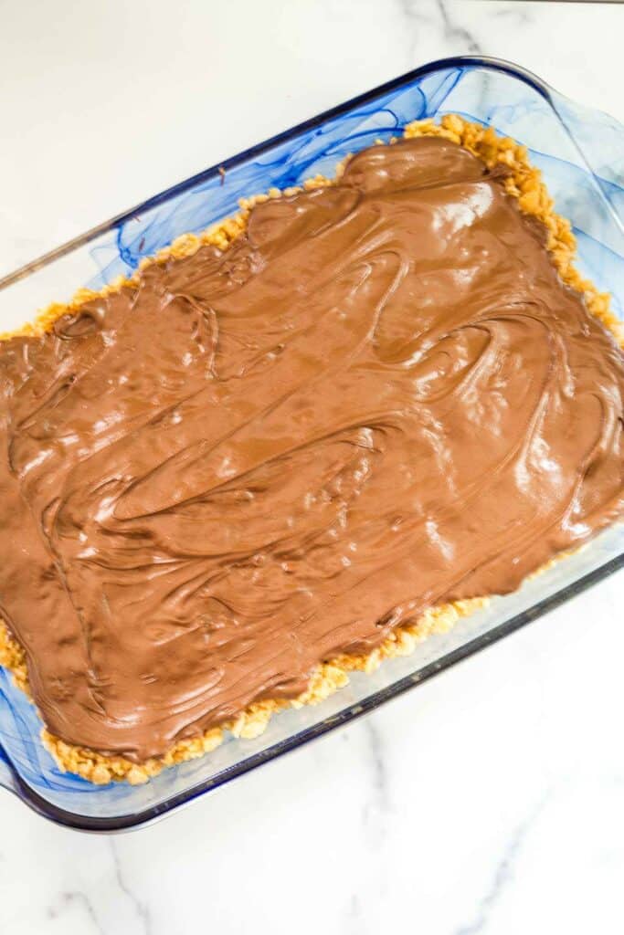 Chocolate mixture spread over top of no bake bars in a 9x13 pan.