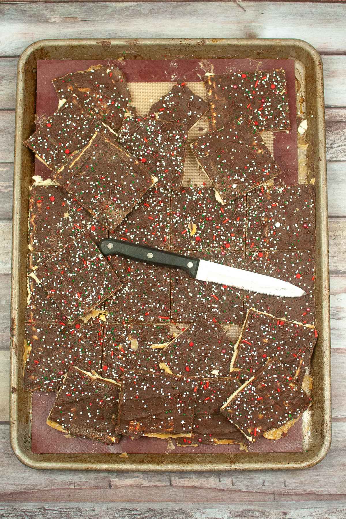 Christmas Crack that has been cut into pieces on the jelly roll pan.