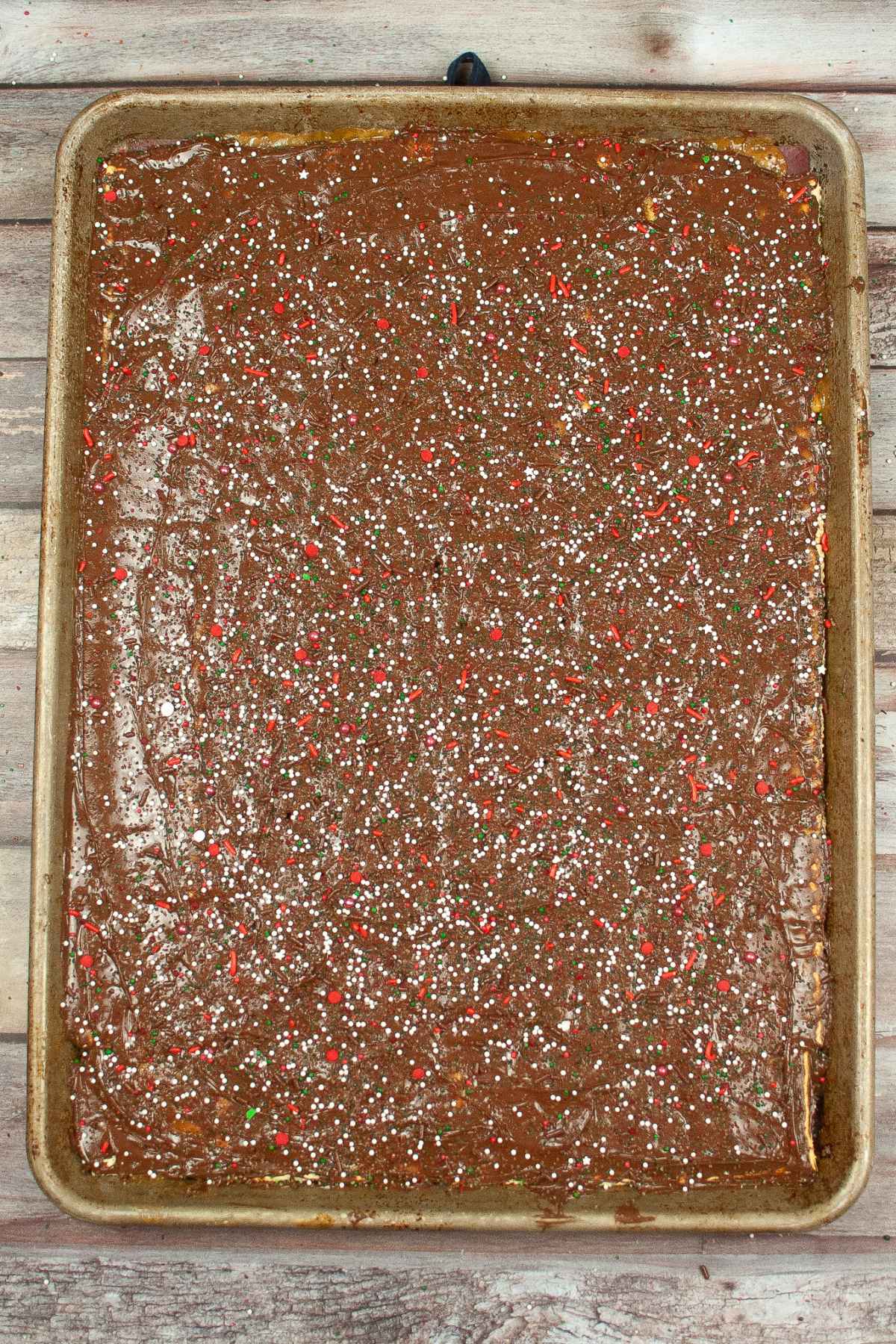 Christmas Crack with chocolate spread over top and red, white, and green sprinkles.