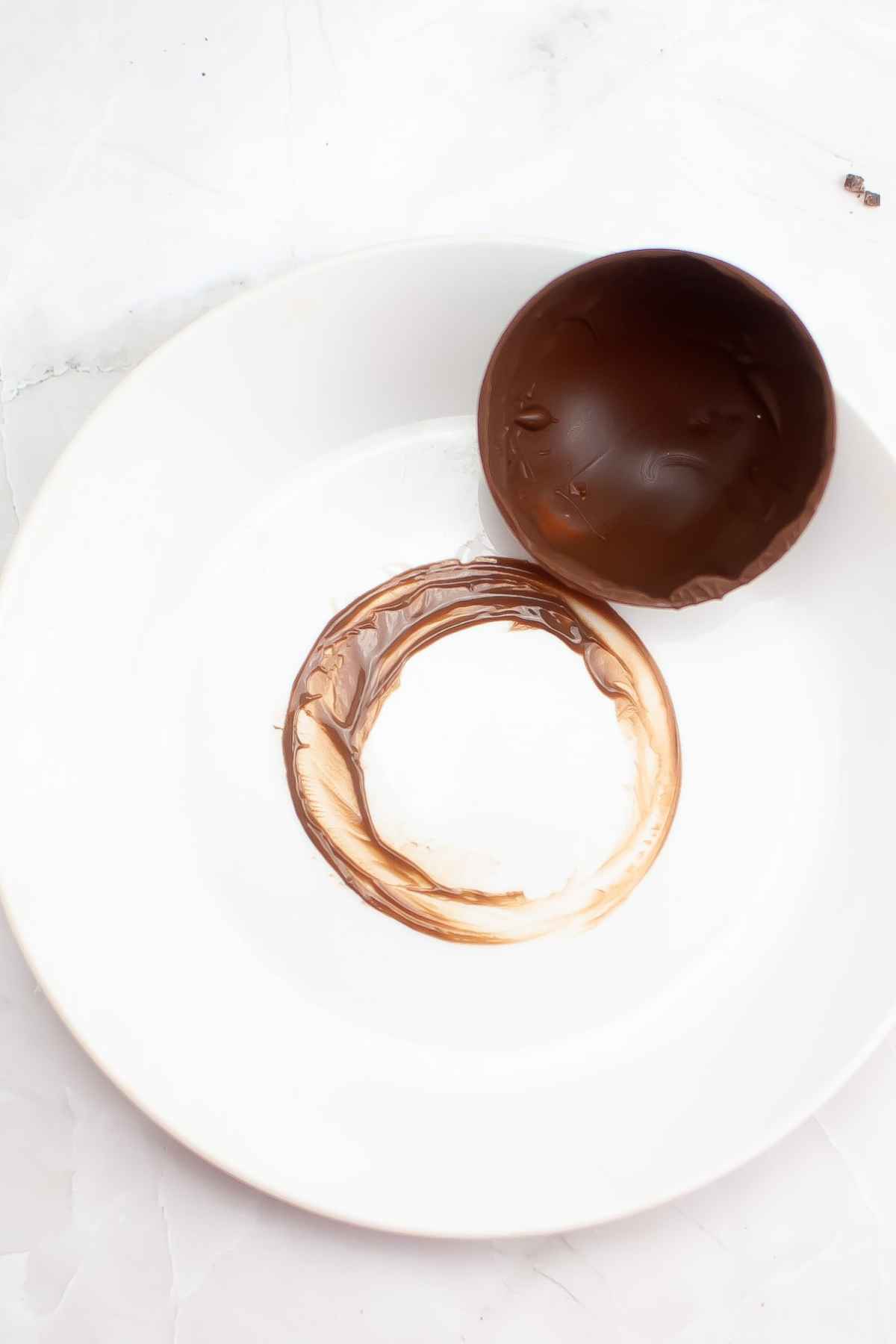 Chocolate half sphere on a white plate.