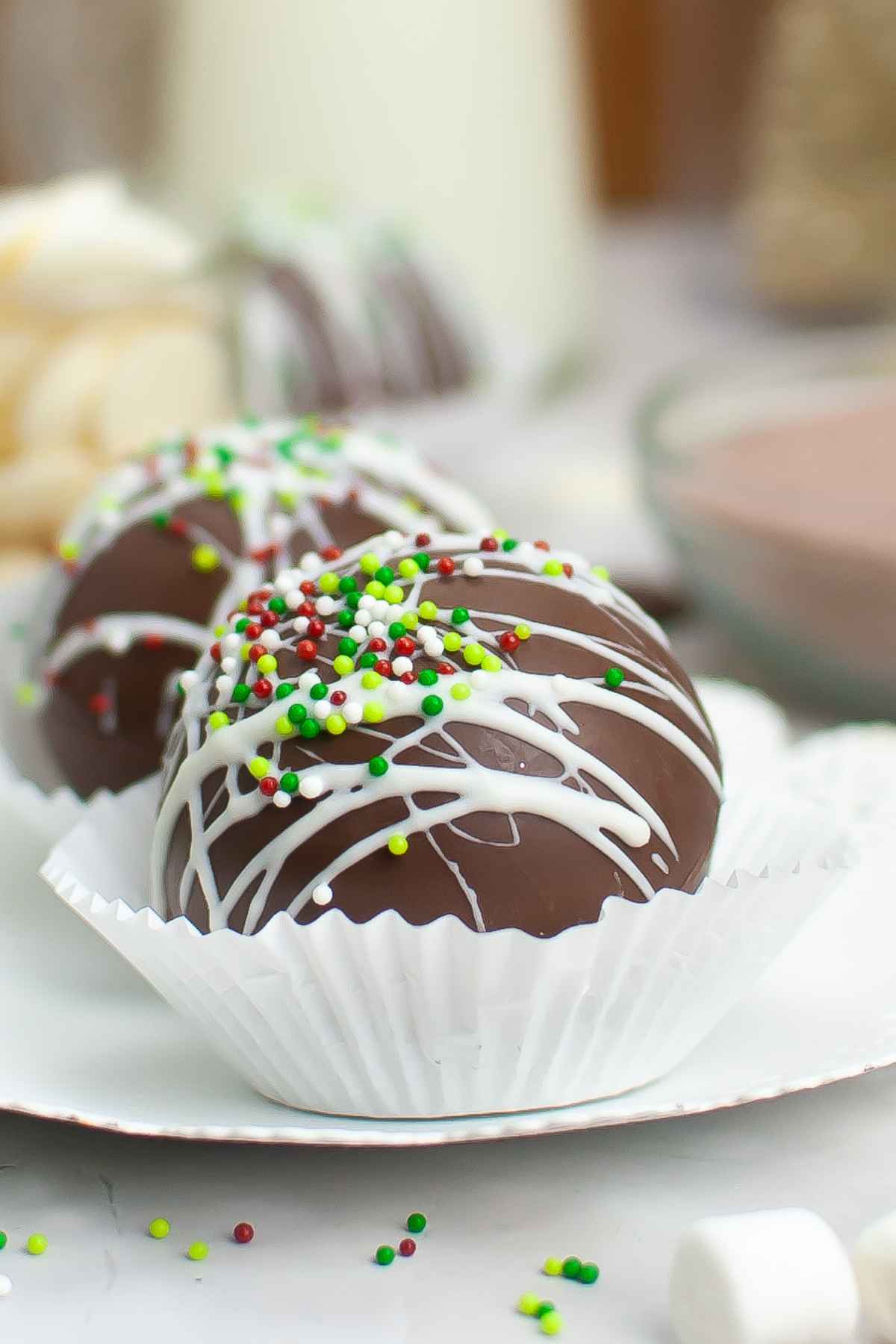 Up close side view of a Christmas Hot Cocoa Bomb in a white cupcake liner.