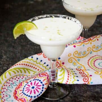 Coconut Lime Margarita with a coconut flake rim and lime wedge.