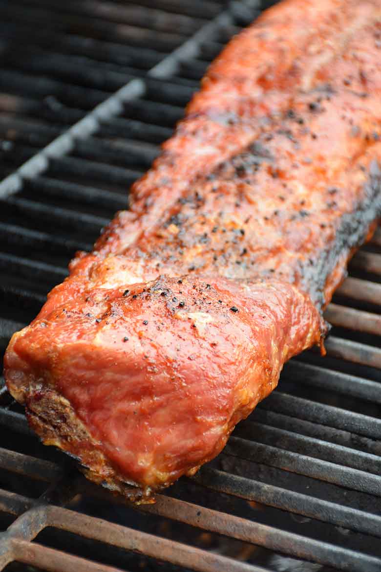 Cooked pork back ribs on the grill before adding sugar-free barbecue sauce