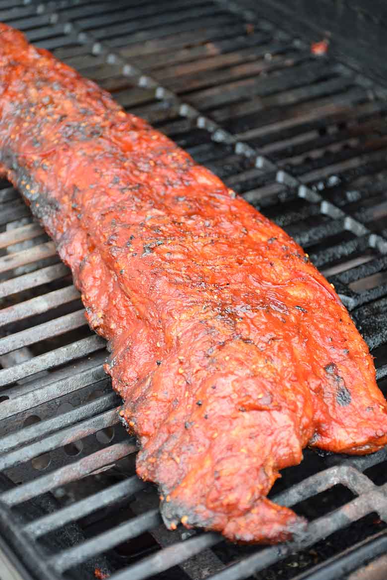 cooked pork back ribs with Raspberry Chipotle Sauce on the grill ready to plate