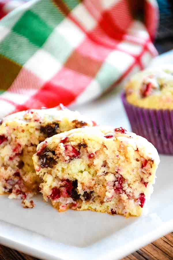 One Cranberry Muffin cut in half on a white plate.